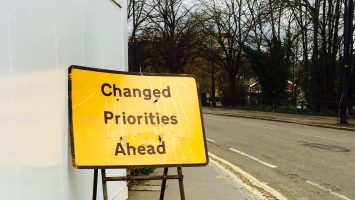 A road sign that says 'priorities changed ahead'